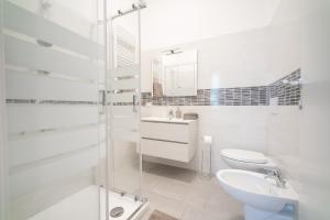 La salle de bains blanche est pourvue de toilettes et d'un lavabo. dans l'établissement Spacious Apartment - 4 Bedrooms and 3 Bathrooms, à Bergame