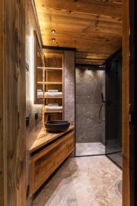 La salle de bains est pourvue d'un lavabo et d'une douche. dans l'établissement Rifugio de Dòo, à San Nicolò di Comelico