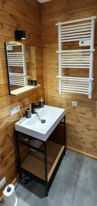 a bathroom with a white sink and wooden walls at Osada Przy Młynie - Tajemnica Twojego Relaksu - W Saunie, Chacie Grillowej in Zagnańsk