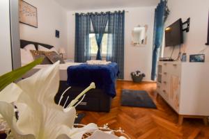 a bedroom with a bed and a table and a tv at Villa Kristina Rab in Supetarska Draga