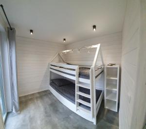 białe łóżko piętrowe w białym pokoju w obiekcie Osada Przy Młynie - Tajemnica Twojego Relaksu - W Saunie, Chacie Grillowej w mieście Zagnańsk