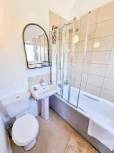 a bathroom with a toilet and a sink and a tub at Milton Keynes Modern City House in Milton Keynes