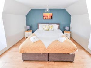 una camera da letto con un grande letto con pareti blu di Milton Keynes Modern City House a Milton Keynes