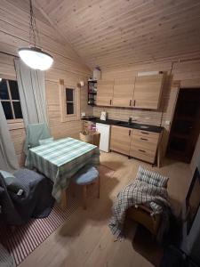 a living room with a table and a kitchen at Sauna cabin in the heart of Nuuksio National Park in Espoo