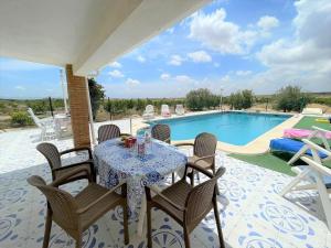 El CaracoleroにあるHoliday home with private pool near Sucinaのプールサイドのパティオ(テーブル、椅子付)
