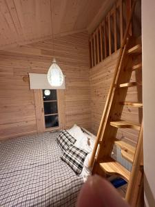 a room with a bunk bed in a wooden cabin at Sauna cabin in the heart of Nuuksio National Park in Espoo