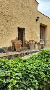 tres jarrones grandes sentados en un lado de un edificio en Casa Rural Lares, en Casas de Don Pedro