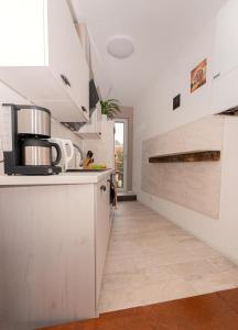 a kitchen with white cabinets and a wooden floor at Temporary Living - Rest and Relax in Eisenach