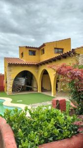 una gran casa amarilla con piscina frente a ella en Casa Rural Lares, en Casas de Don Pedro