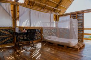 een kamer met een bed, een bureau en een stoel bij Niuwi Hostel in Buritaca