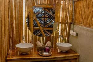 uma casa de banho com duas tigelas num balcão de madeira em Niuwi Hostel em Buritaca