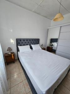 a bedroom with a large white bed and a night stand at Melidron in Lixouri