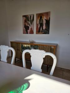 two white chairs sitting in front of a table at Melidron in Lixouri