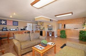 ein Wohnzimmer mit einem Sofa und einem Tisch in der Unterkunft Americas Best Value Inn Crosstimbers in Stephenville