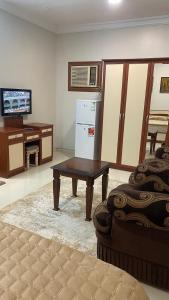 a living room with a refrigerator and a table at غرفه ديلوكس ٤٥م بقلب المدينه بالقرب من المسجد المبوي in Medina