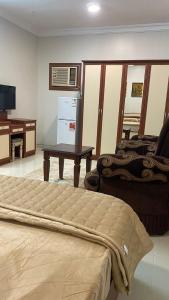 a room with a bed and a table and a desk at غرفه ديلوكس ٤٥م بقلب المدينه بالقرب من المسجد المبوي in Medina