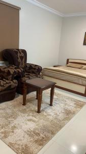 a bedroom with a bed and a table and a couch at غرفه ديلوكس ٤٥م بقلب المدينه بالقرب من المسجد المبوي in Medina