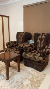 a living room with two chairs and a coffee table at غرفه ديلوكس ٤٥م بقلب المدينه بالقرب من المسجد المبوي in Al Madinah