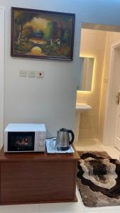 a microwave sitting on top of a wooden table at غرفه ديلوكس ٤٥م بقلب المدينه بالقرب من المسجد المبوي in Al Madinah