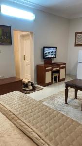 a bedroom with a bed and a desk and a television at غرفه ديلوكس ٤٥م بقلب المدينه بالقرب من المسجد المبوي in Medina