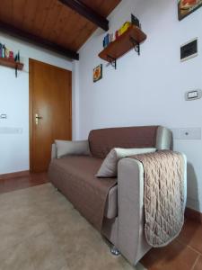 un sofá en una sala de estar con puerta de madera en Francesca Home - Relax in Villa, en Piedimonte Etneo