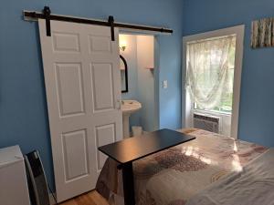 um quarto com uma porta e uma cama com uma mesa em Inn on Frederick em Saint Andrews