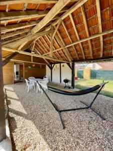 a hammock under a pavilion with a table and chairs at la Casa d'Olianna - Jolie Maison / Jeux / Grand jardin in Villeny