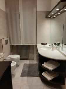 bagno con lavandino, servizi igienici e specchio di Blue House a Borgomanero