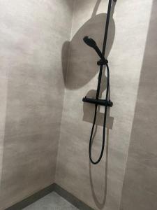 a shower with a shower head on a wall at Mysig lägenhet på landet. in Ljung