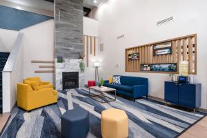 Comfort Inn & Suites Hampton near Coliseum في هامبتون: غرفة معيشة مع كنب ومدفأة