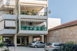 um edifício de apartamentos com carros estacionados num parque de estacionamento em Thanos Luxury home em Volos