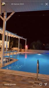 ein großer Pool in der Nacht mit Areens in der Unterkunft GARDEN ASMİN OTEl&SPA in Kızılbağ