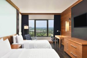 a hotel room with two beds and a flat screen tv at Le Meridien New Delhi in New Delhi