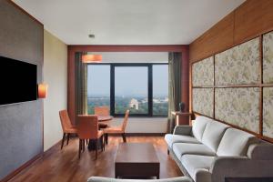 a living room with a couch and a table at Le Meridien New Delhi in New Delhi