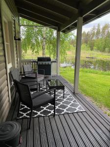a screened porch with two chairs and a grill at Rantakatti Apartments in Punkaharju