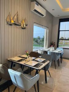 烏姆拉吉的住宿－Wissam Al-Hawra Hotel，餐厅设有桌椅和大窗户。