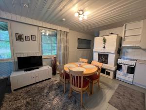 a kitchen and dining room with a table and a television at Rantakatti Apartments in Punkaharju