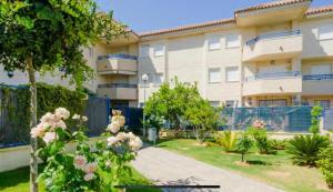 an apartment building with a garden in front of it at ÁTICO BAJO GUÍA in Sanlúcar de Barrameda