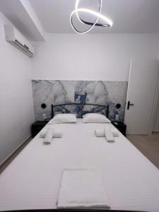 a large white bed in a bedroom with a chandelier at Mano’s House Preveza 2 in Preveza