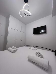 a white bedroom with a bed with towels on it at Mano’s House Preveza 2 in Preveza