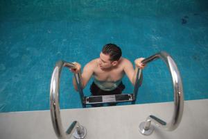 a man in a bath tub in a swimming pool at HOTEL OSHO in Santa Cruz de la Sierra