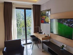 a living room with a large tv and a desk and a couch at Genting HillTop @ Ion Highland Resort in Genting Highlands