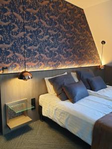 a hotel room with a bed and a wall with a pattern at Het Pauwtje in Zoutelande