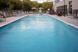 a large swimming pool with chairs in a building at TownePlace Suites by Marriott Orlando Airport in Orlando