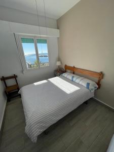 a bedroom with a large bed with two windows at APARTAMENTO PRIMERA LINEA PLAYA in San Pedro del Pinatar