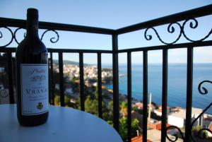 a bottle of wine sitting on a table on a balcony at Captain's View in Dobra Voda