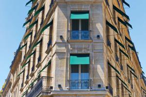 fachada de un edificio con ventanas y balcones en Le Metropolitan Paris Tour Eiffel, a Tribute Portfolio Hotel, en París