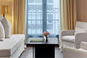 a living room with a couch and a chair and a table at Le Metropolitan, Paris Tour Eiffel, a Tribute Portfolio Hotel in Paris