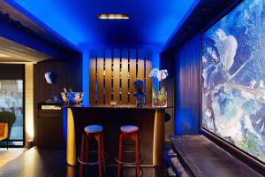 a bar with two stools and a blue ceiling at Le Metropolitan Paris Tour Eiffel, a Tribute Portfolio Hotel in Paris