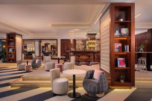 a lobby with chairs and tables and a library at Hotel Ercilla de Bilbao, Autograph Collection in Bilbao